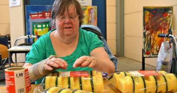 vrouw pakt gele schuursponjes
