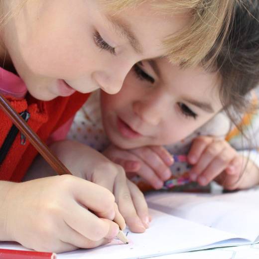 Twee kinderen buigen zich over schoolwerk
