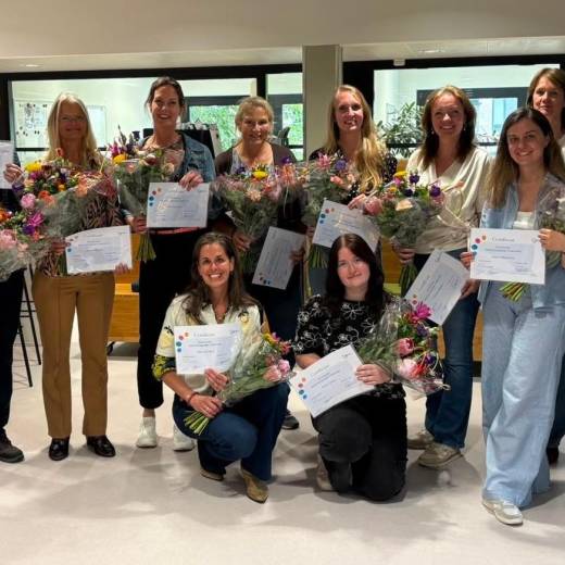 Groepsfoto deelnemers en docenten Masterclass Wetenschappelijk Onderzoek  met hun certificaat en bloemen