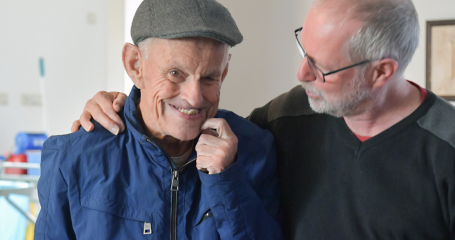 Zorgmedewerker omarmt glimlachende client