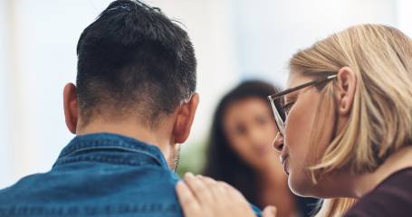 Afbeelding van een begeleider die haar hand steunend laat rusten op de schouder van een cliënt. Staat voor forensische zorg.