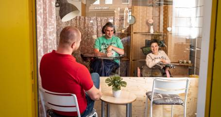 man praat met man en vrouw met een beperking via raam bij Middin Boergoensestraat