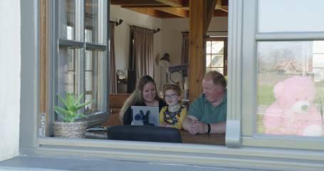 man en vrouw met kind tussen hun in kijken naar monitor