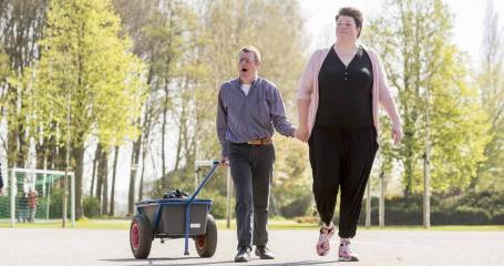 Wandeling van een begeleidster met een client met beperking bij zorginstelling Elver