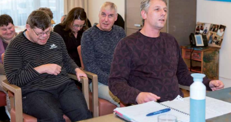 mensen zitten in zaal op stoelen