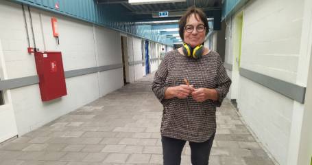 vrouw staat in gang en kijkt in camera