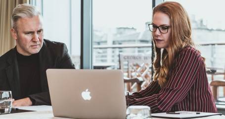 man en vrouw kijken naar appel laptop