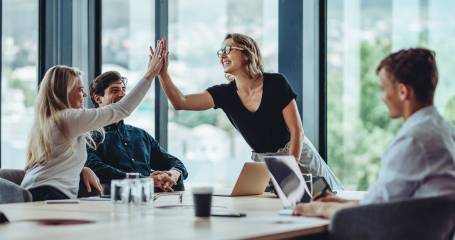 mensen aan tafel geven een high five
