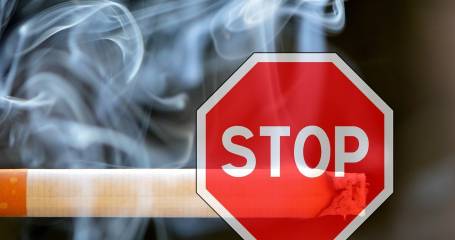 Brandende sigaret met daarvoor een stopbord