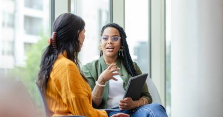 Twee dames die zittend in gesprek zijn