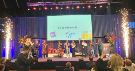 Podium met daarop finalisten en juryleden van de pioneers award. Floow.ai neemt bloemen en de cheque in handen na de winst.