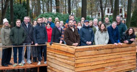mensen staan lachend op de foto geposeerd in een bos