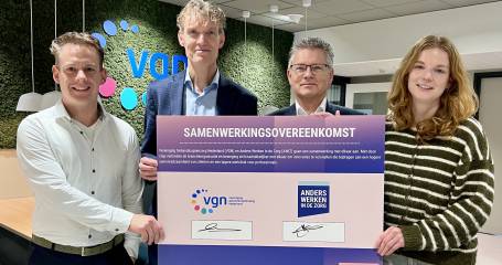Vier personen met de cheque waarop de samenwerking is ondertekend