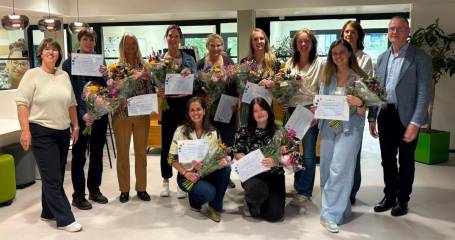 Groepsfoto deelnemers en docenten Masterclass Wetenschappelijk Onderzoek  met hun certificaat en bloemen
