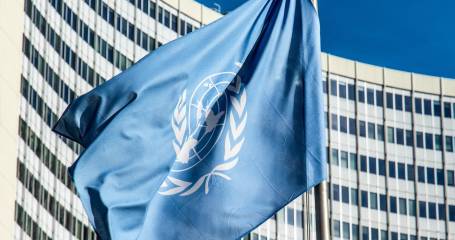 un vlag wappert aan paal voor kantoorgebouw