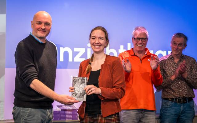 Staatssecretaris Pouw ontvangt het eerste exemplaar van het boek Onzichtbaar uit handen van Boris van der Ham