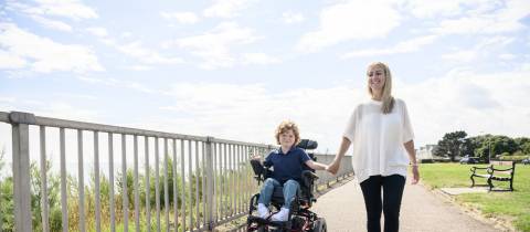 Moeder met zoon in elektrische rolstoel
