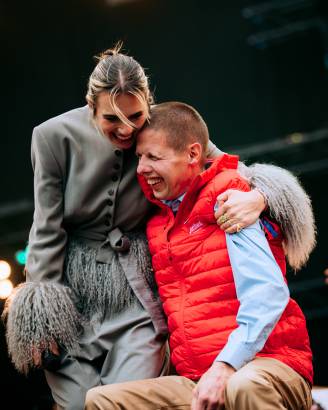 maan en lid jostiband knuffelen op het podium