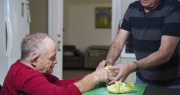 Twee mensen die salade maken