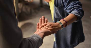 Hand die een andere hand ondersteunt