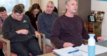 mensen zitten in zaal op stoelen