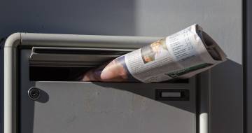 krant steekt uit brievenbus