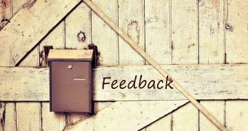 Brievenbus hangt aan houten deur met woord feedback erop