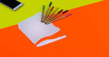 gescheurd papier met potloden en smartphone