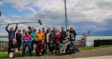 groep mensen staat voor een zeilboot