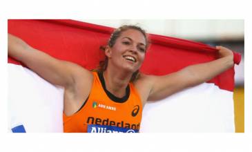 Atlete Marlou van Rhijn houd nederlandse vlag vast en glimlacht