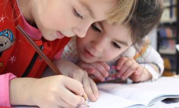 Twee kinderen buigen zich over schoolwerk