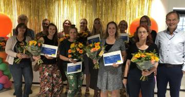 Docenten en cursisten met certificaat en bloemen en VGN-directeur Frank Bluiminck