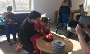 Oekraïense kinderen en ouders vieren verjaardag in een woonkamer