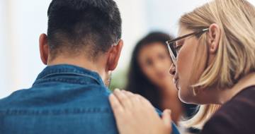 Vrouw legt hand op iemands schouder