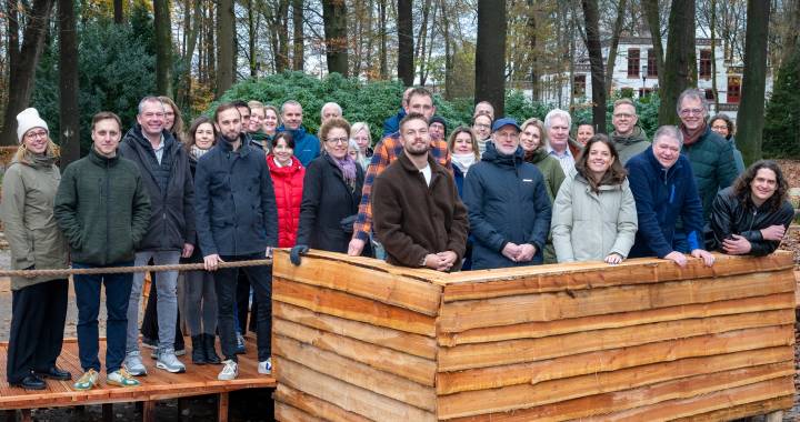 mensen staan lachend op de foto geposeerd in een bos