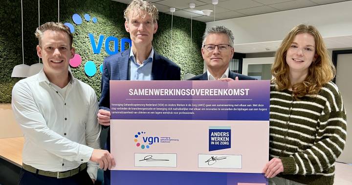 Vier personen met de cheque waarop de samenwerking is ondertekend