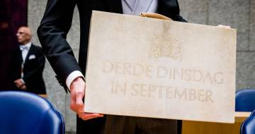 man houd koffer vast met tekst derde dinsdag in september