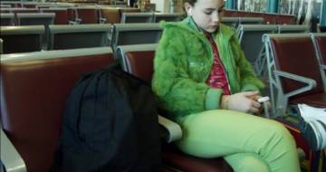 vrouw met groene kleding zit op stoel