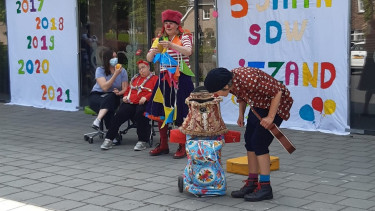 Afbeelding van bewoners en clowns op het feest van woonlocatie 't Zand