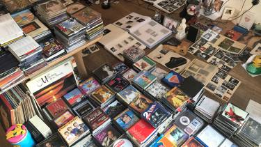 Een grote verzameling platen, fotoboeken en cd's ligt tentoongesteld op de grond