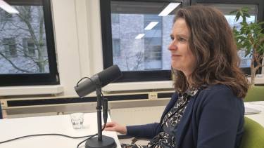 Petra Egbers zit achter microfoon en kijkt voor zich uit