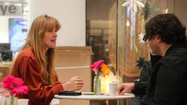 Vrouw is in gesprek met twee mensen van de rug gezien